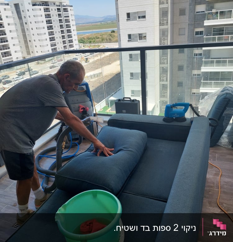 אדם מנקה ספה עם מכונת ניקוי ומים